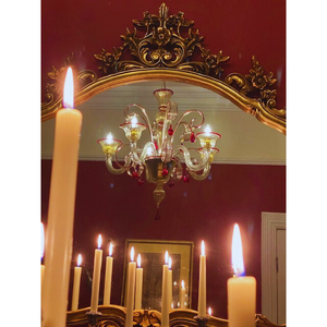 Close-up of Murano glass chandelier reflecting candlelight in a vintage-inspired room