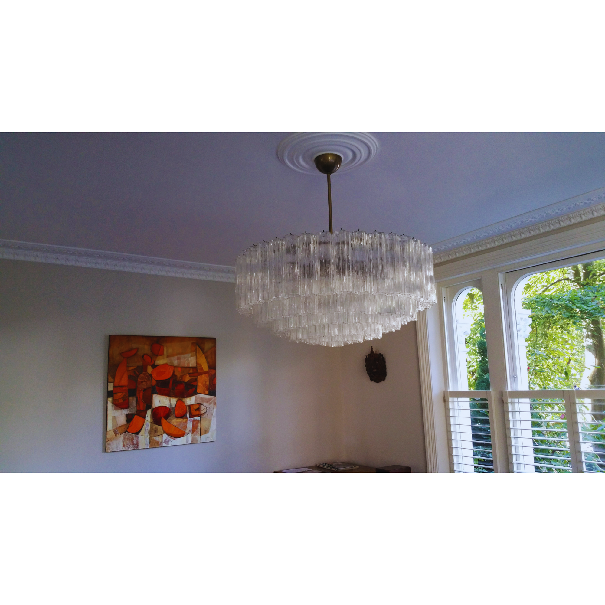 The chandelier viewed from below, showing the drum shape and individual "tronchi" glass pieces.