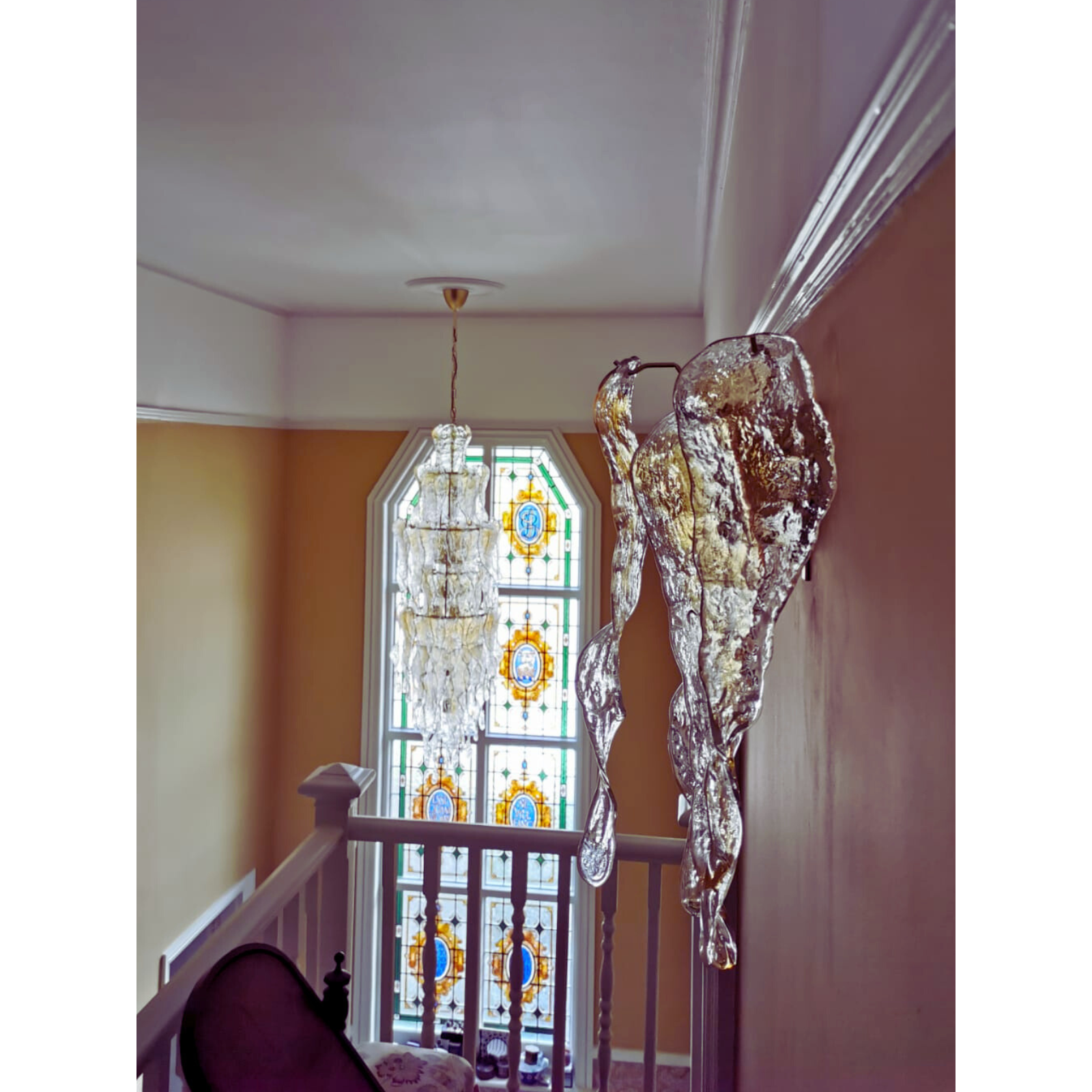 Close-up of amber and clear Murano glass chandelier against a decorative wallpapered wall