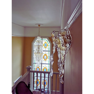 Close-up of amber and clear Murano glass chandelier against a decorative wallpapered wall