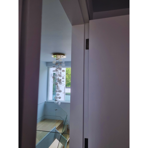 View of a modern bubble chandelier with frosted and clear glass spheres hanging elegantly in a stairwell.