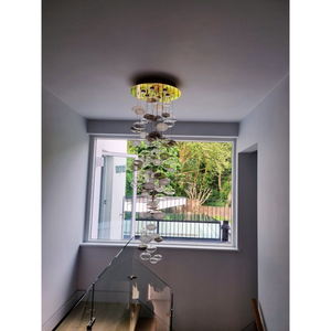 Full view of a bubble chandelier in a stairwell, showcasing clear and frosted glass spheres.