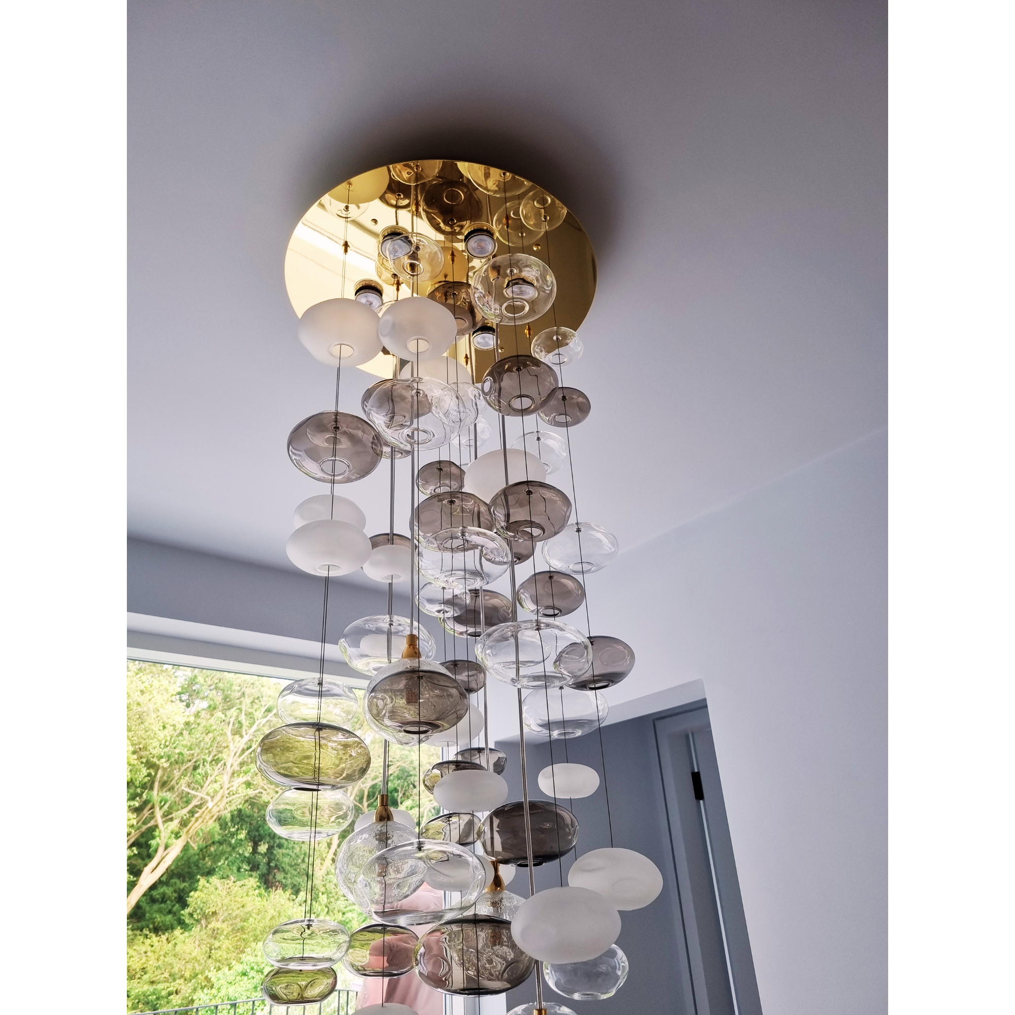 Ceiling-mounted bubble chandelier with clear and frosted glass orbs, designed for a modern interior.