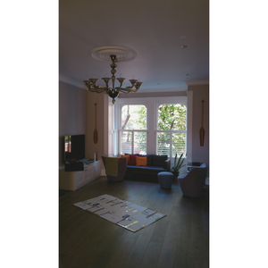 Full view of a classic room featuring the chandelier, a TV area, and large windows.