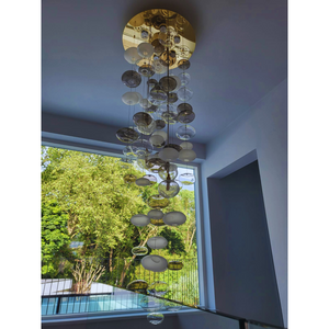 Bubble chandelier set against a minimalist stairwell, featuring clear and frosted glass elements.