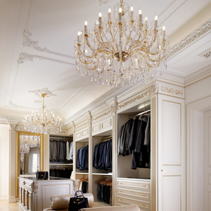 Elegant walk-in wardrobe adorned with Maria Theresa style crystal chandeliers, enhancing the sophisticated interior with golden accents and tailored storage solutions.